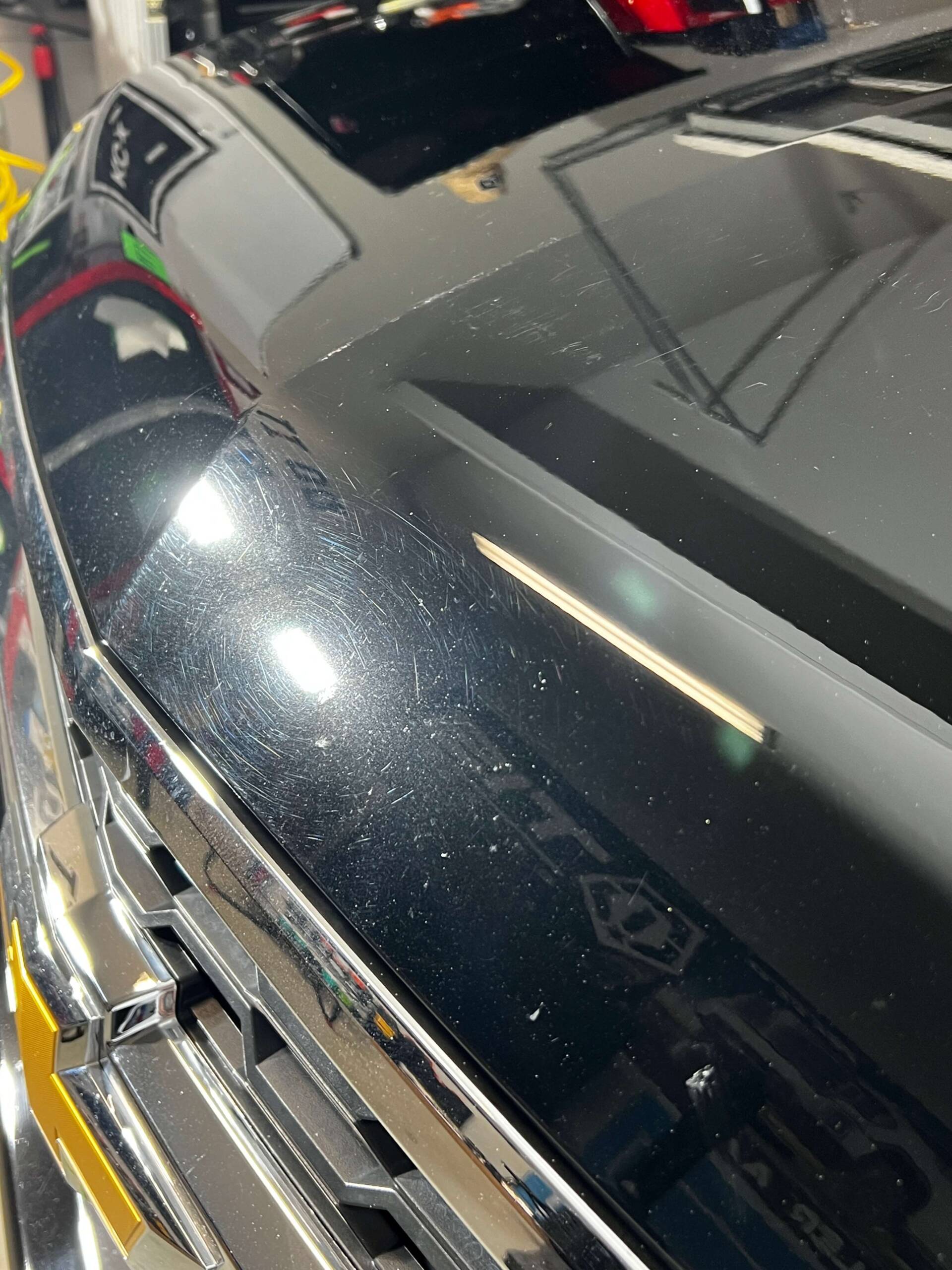 hood of black truck with swirl marks